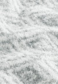 Grijze en witte geweven stof met een zachte, pluizige textuur en subtiele patronen, die verschillende tinten toont en een fluffy uitstraling heeft.