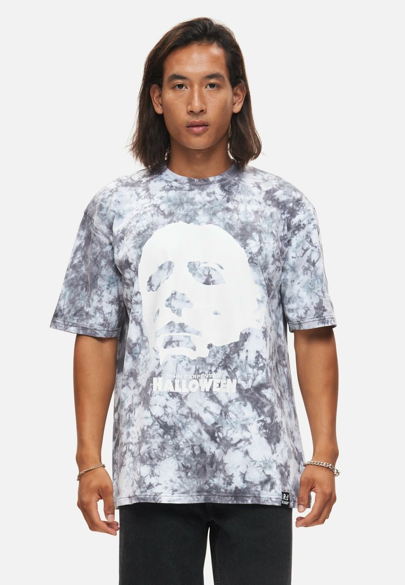 Grå och vit tie-dye t-shirt med en stor vit grafisk bild av ett ansikte och texten "HALLOWEEN", korta ärmar, lös passform, bomullsblandad tyg.