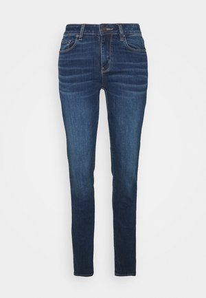 Donkerblauwe skinny jeans van denim, met een medium hoogstaande taille, voorzakken en licht beschadigde details op de dijen.
