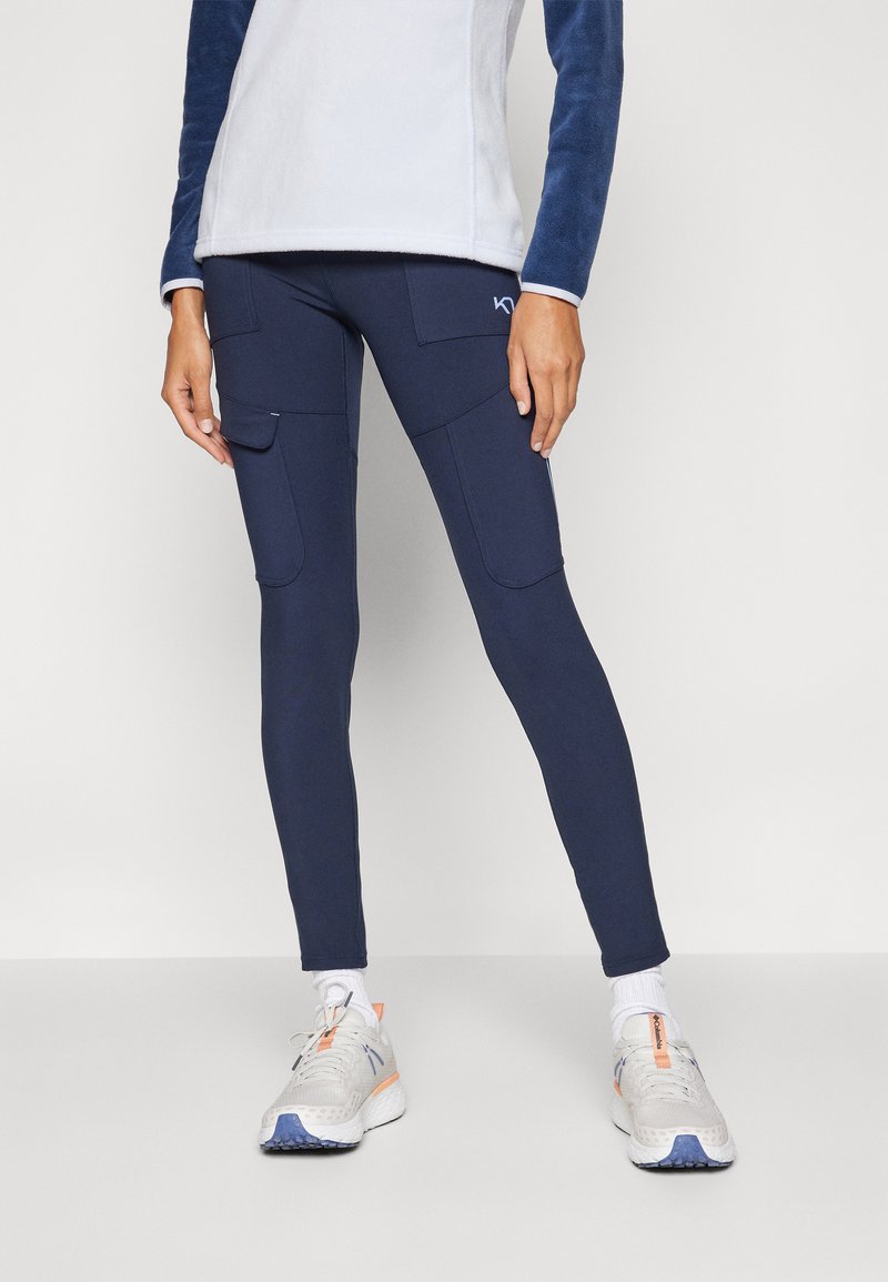Marinebl�å leggings med en tettsittende design, sidelommer og elastisk stoff. Kombinert med hvite og grå sportssko for en komplett look.