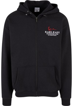 Black zip-up hoodie featuring a front pocket, ribbed cuffs and hem, and embroidered logo in white and red. Soft, textured fabric.