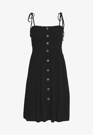 Robe noire avec corsage smocké, bretelles ajustables et fermeture boutonnée à l'avant avec des boutons arrondis. Jupe évasée avec une finition texturée.