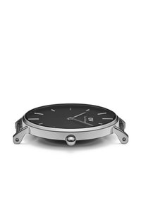 Montre-bracelet fine avec cadran noir, boîtier et couronne argentés, profil latéral sans bracelet, sur fond blanc.