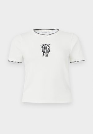 T-shirt bianca a maniche corte con bordi neri e un design ricamato in nero che raffigura una ragazza che tiene un fiore sopra la parola "GAP."