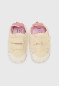 Μπεζ καμβαδένια παπούτσια με ροζ λεπτομέρειες, διαθέτουν λουριά με βέλκρο, λευκό καουτσούκ μύτη και εσωτερική φόδρα με ρίγες.