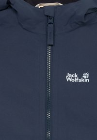 Námornícky modrá bunda vyrobená z vodoodpudivého materiálu, s predným zipsom, vysokým golierom a bielym logom potlačeným na hrudi.