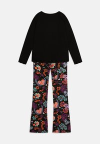 Black long-sleeve top paired with colorful, patterned leggings featuring hearts and flowers on a black background, in a relaxed fit.