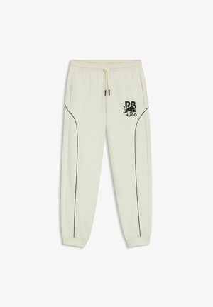 Pantalon de jogging blanc avec passepoil noir, poignets élastiques, taille à cordon, poches latérales et logo RB HUGO noir sur la cuisse gauche.