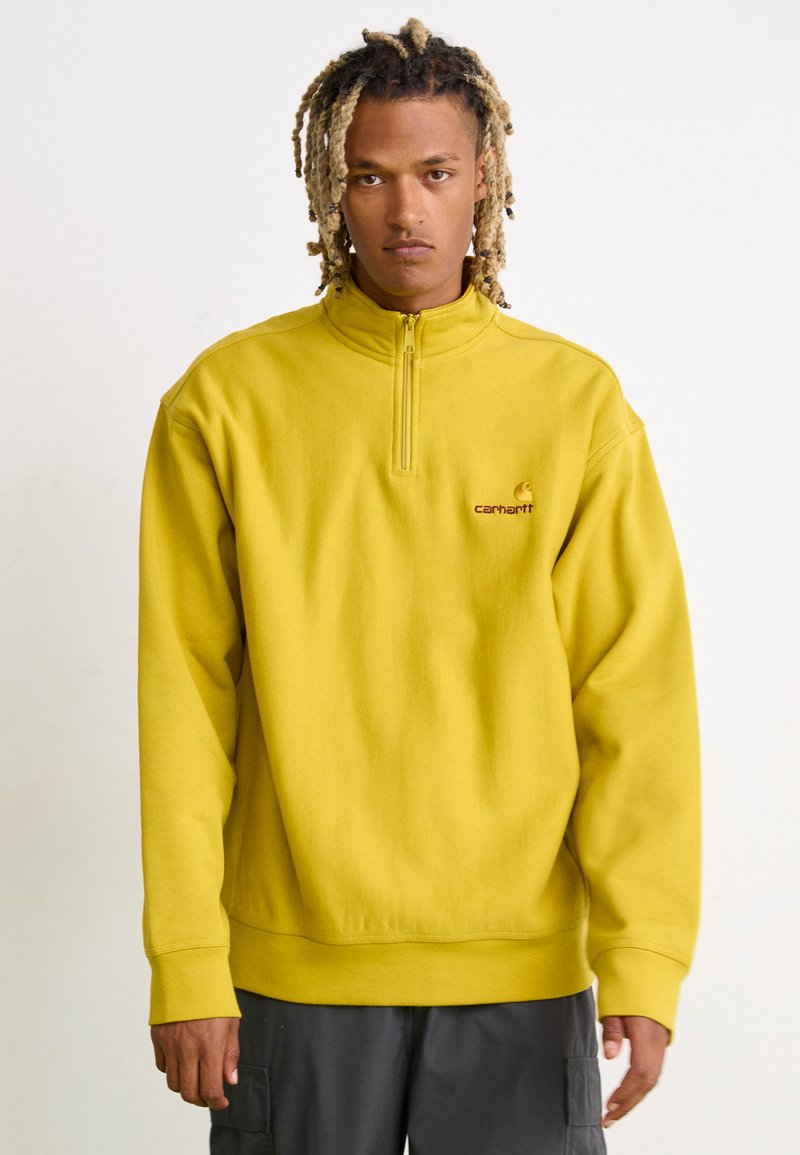 Geel pullover sweatshirt met een hoge kraag en een kwart-ritssluiting aan de voorkant. Voorzien van ribgebreide manchetten en zoom, verfraaid met een klein geborduurd logo.