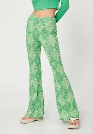 Groene uitlopende broek van textiel met een diamanten patroon in verschillende tinten groen. Het heeft een hoge tailleband en losse pijpen.