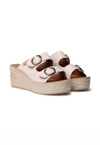 Sandali con zeppa caratterizzati da una parte superiore beige e testurizzata con due fibbie metalliche regolabili, suola in juta intrecciata e design con punta aperta.