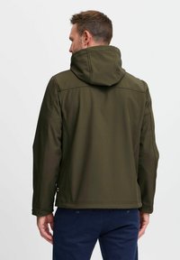 Olivgrüne Jacke mit hohem Kragen und Kapuze, aus glattem Stoff und mit kontrastierenden Nähten. Minimalistisches Design, keine sichtbaren Muster.