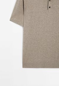 Polo beige à manches courtes avec une patte à trois boutons, tissu en maille texturée, ourlet et poignets côtelés.