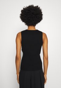Top nero senza maniche in maglia ribattuta, con un collo rotondo e una forma aderente, caratterizzato da una texture liscia e senza motivi o decorazioni visibili.