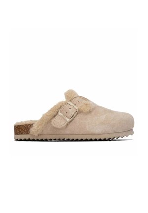 Zueco beige de poner y quitar con forro suave de piel, tira ajustable de ante con hebilla, plantilla de corcho y suela de goma estriada para mayor agarre.