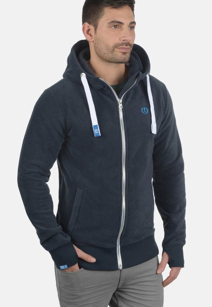 Sudadera con cremallera de forro polar azul marino con cordones blancos, bolsillos laterales y puños acanalados. Presenta un pequeño logo en el pecho.