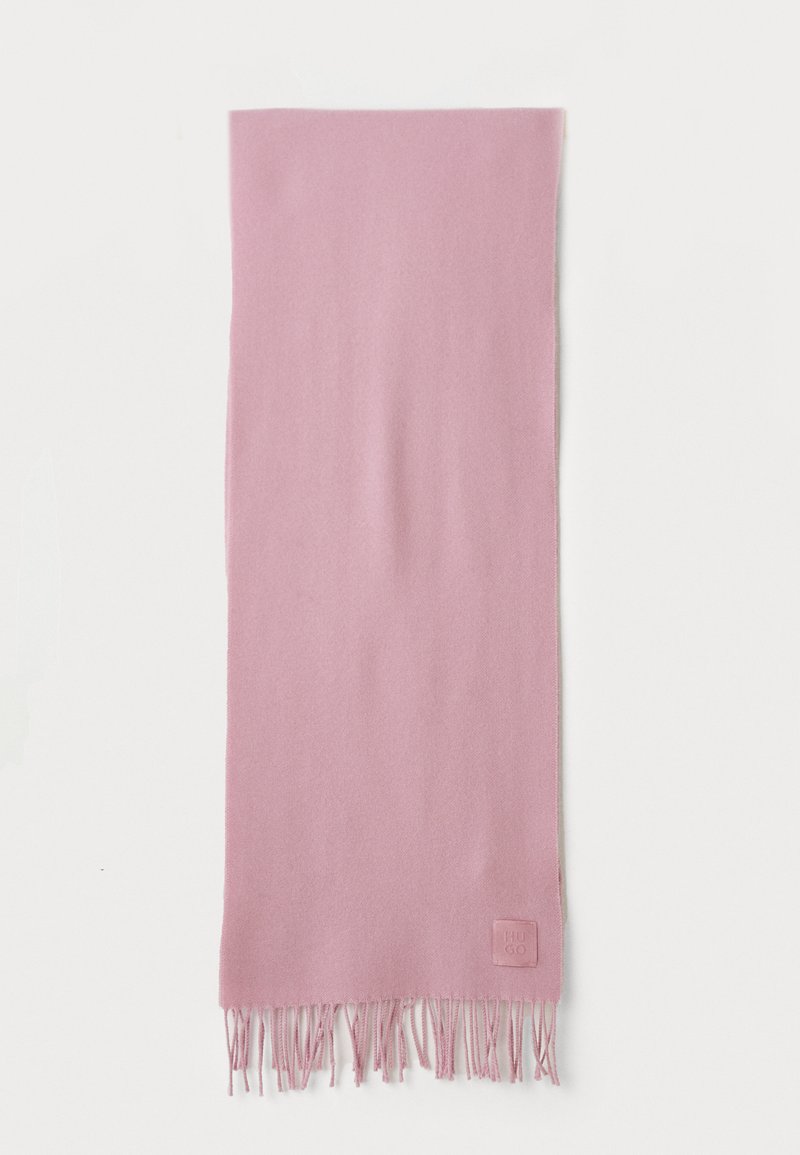 Soft pink rectangular scarf with fringe ends and a small embossed logo tag on one corner, laid flat on a white background.