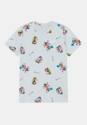 T-shirt Nike bleu clair avec des graphismes répétés sur le camping et la pêche en plein air, comprenant des tentes, des hameçons et des logos Nike.