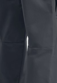 Wasserdichte Jacke aus dunkelgrauem Material mit glatter Textur, ausgestattet mit einem taillierten Design und nahtlosen Nähten für eine ergonomische Passform.