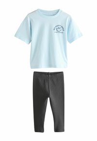Svetlomodré tričko s krátkym rukávom a grafikou usmievajúcej sa tváre, spolu s šedými rebrovanými legínami, navrhnuté pre pohodlie a neformálne nosenie.