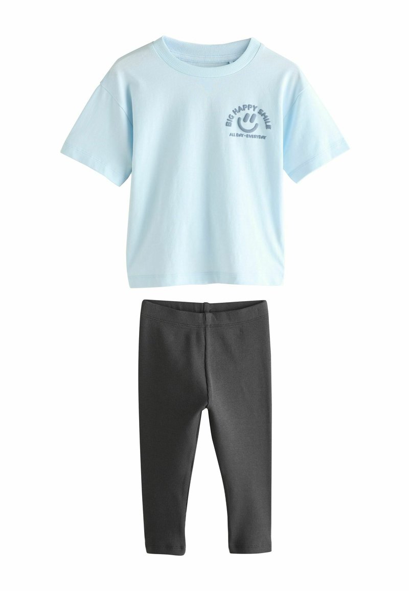 Svetlomodré tričko s krátkym rukávom a grafikou usmievajúcej sa tváre, spolu s šedými rebrovanými legínami, navrhnuté pre pohodlie a neformálne nosenie.