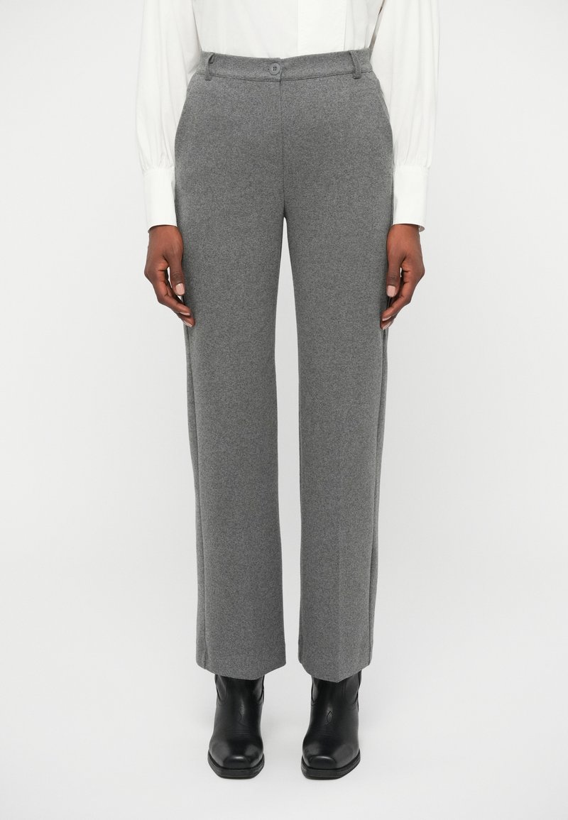 Gray wool blend trousers with a straight leg design, waistband button, and front pockets, paired with black ankle boots.
