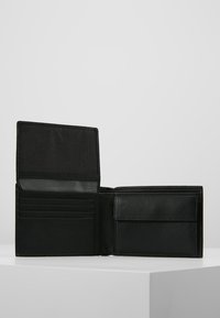 Portefeuille en cuir noir au design ouvert, avec plusieurs emplacements pour cartes, une poche transparente et un intérieur texturé.