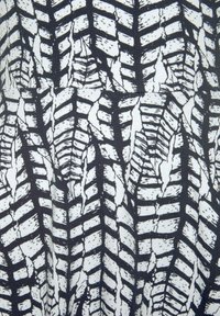 Schwarz-weißer Stoff mit einem Reifenprofilmuster, das strukturierte Linien und unterschiedliche Breiten aufweist und einen geometrischen visuellen Effekt erzeugt.