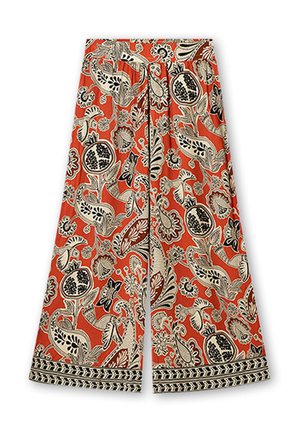 Wide-leg pants in orange fabric, featuring black and beige floral patterns, with a detailed hem and a tied waist for secure fit.