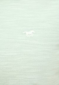 Jasnozielona dzianinowa koszulka polo z subtelnym, białym haftowanym logo konia. Miękka w dotyku, o lekkiej i przewiewnej konstrukcji.