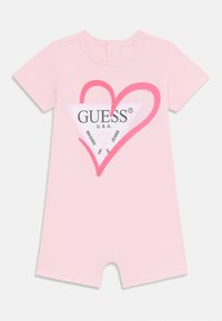 Monito de manga corta rosa con un gran gráfico de triángulo blanco que incluye texto en negro y un contorno de corazón rosa. Cierre a presión en el cuello.