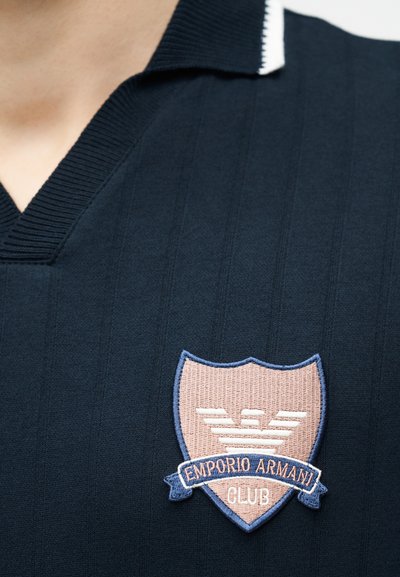 Μπλε ριπ μπλουζάκι πόλο με ριμπ γιακά και κεντημένο λογότυπο της ασπίδας του Emporio Armani Club στο στήθος.