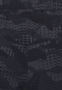 Musta kangas, jossa on teksturoitu, abstrakti kuvio tummanharmaana. Sisältää vetoketjullisen taskun, jossa on hieno vetoketju ja kontrastiväri ompelut.