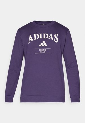 Lila sweatshirt med långa ärmar, rund hals och vit Adidas-logotyp. Har texten "TENNIS KLUBB" och klassisk passform. Blandmaterial av bomull.
