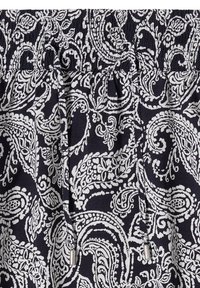 Tissu à motif paisley noir et blanc avec une taille élastique et deux cordons pendants avec embouts métalliques.