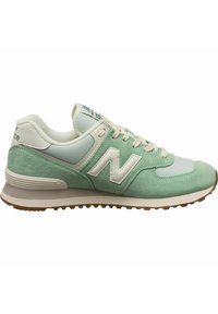 Baskets New Balance vert clair et blanc avec détails en daim, laçage à l’avant et semelle rembourrée avec une semelle en caoutchouc crantée.