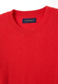 Maglione rosso a maglia con scollatura rotonda. Presenta un colletto e un orlo a costine e include un'etichetta con la scritta "PIOMBO" in lettere dorate.