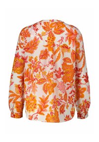 Blumenbluse mit langen Ärmeln in Weiß mit lebhaften orangen und pinken Mustern. Weicher Stoff mit lockerer Passform und abgerundetem Saum.