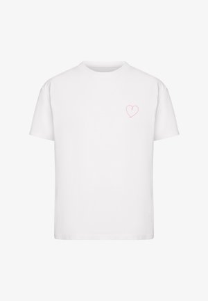 T-shirt blanc à manches courtes avec un petit contour de cœur rouge fin sur le côté gauche de la poitrine, fond uni.