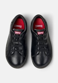 Sneakers neri in pelle con finitura texturizzata, dotati di punta rotonda, lacci e interno rosso con il marchio "CAMPER" sulla linguetta.