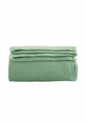 Pehmeä vihreä fleece-torkkupeitto siististi taiteltuna valkoista taustaa vasten.