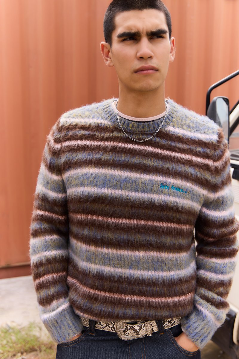 Texturovaný svetr s vodorovnými pruhy v odstínech hnědé, modré a růžové, volný střih a žebrované manžety. Ozdobené vyšívaným textem.