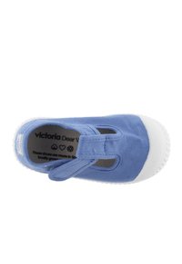 Scarpa di tela blu con punta in gomma bianca, cinturino regolabile e fori traspiranti. Etichette visibili sulla soletta interna per il marchio.