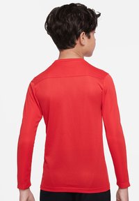 Rotes Langarmshirt mit glatter Textur, Rundhalsausschnitt und taillierten Ärmeln, das eine subtile Stickerei über den Schultern aufweist.