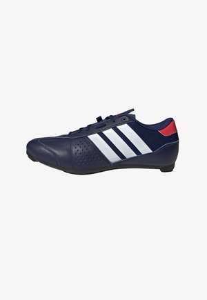 Navy blue athletic shoe with leather and mesh materials, featuring white three-striped design and perforated detail on the side. Red accent on heel.