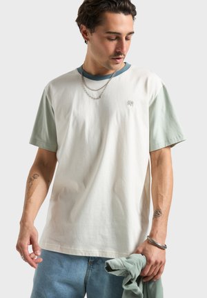 Kortærmet T-shirt i bomuld med hvid krop og pastelgrønne ærmer, med en lille elefantlogo på brystet.