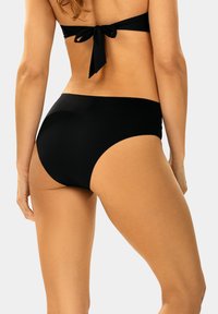 Czarne bikini z wysokim stanem, wykonane z gładkiego, elastycznego materiału i prostych linii, o minimalnym kryciu i bez widocznych elementów metalowych.