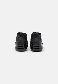 Black sports shoes with a mesh upper and sleek design. The shoes feature glossy black accents and a cushioned sole for comfort.