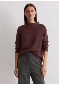 Maroon gebreide trui met een hoge hals en lange mouwen, gecombineerd met grijze op maat gemaakte broek. Zachte textuur en een casual pasvorm zijn zichtbaar.