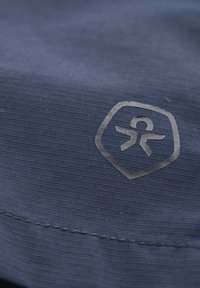 Marinblått tyg med fin ribbstruktur, med en grå präglad logotyp inom en hexagonform längs en söm.